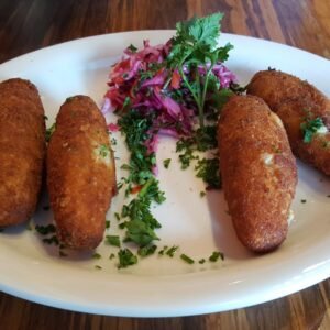 a white plate topped with four fried food items